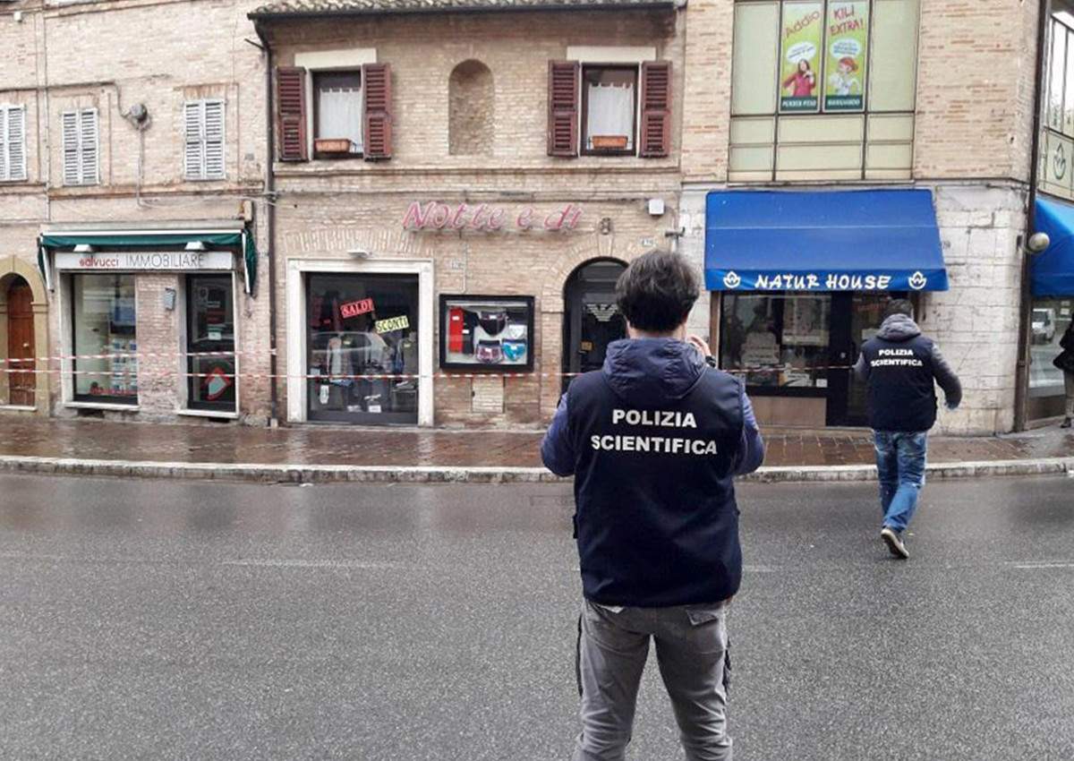 Italian Forensic policemen take pictures to the site of a shooting which broke out in Macerata, Italy, Saturday, Feb. 3, 2018.