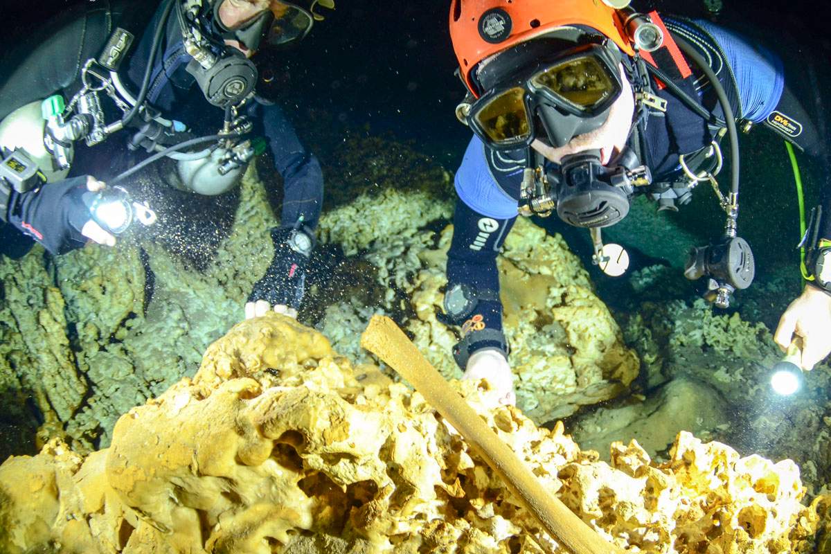 This undated photo released by Mexico’s National Anthropology and History Institute (INAH), shows divers from the Great Mayan Aquifer project exploring the Sac Actun underwater cave system where Mayan and Pleistocene bones and cultural artifacts have been found submerged, near Tulum, Mexico.