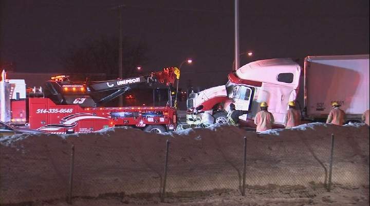 A jack-knifed tractor -trailer is being towed away on Highway 40 East, near Montreal, Saturday, Feb. 3, 2018.