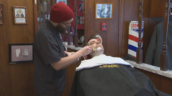 Russ Hobson gets a straight edge shave to start the beard growing contest.