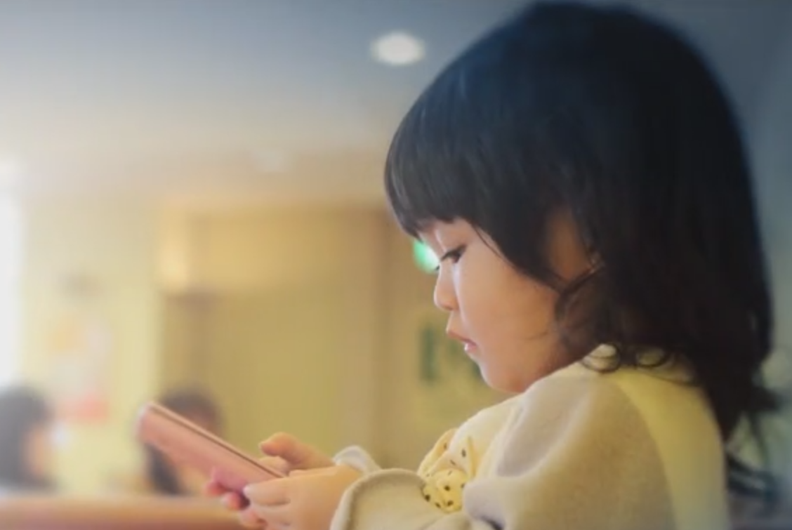 A toddler using an electronic device.