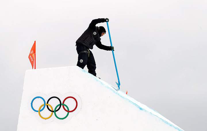 An Olympics official works on the slope after the women’s snowboard slopestyle qualification round was cancelled due to heavy wind. 
