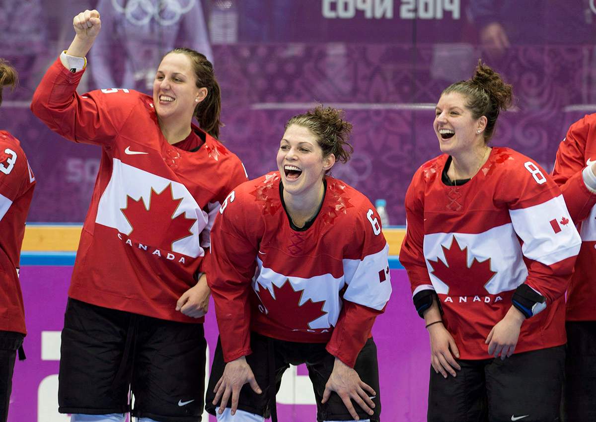 Canada’s Lauriane Rougeau, Rebecca Johnston, and Laura Fortino, left to right, celebrate after beating the USA 3-2 in overtime to win the gold medal in the women’s hockey final at the Sochi Winter Olympics Thursday, February 20, 2014 in Sochi.