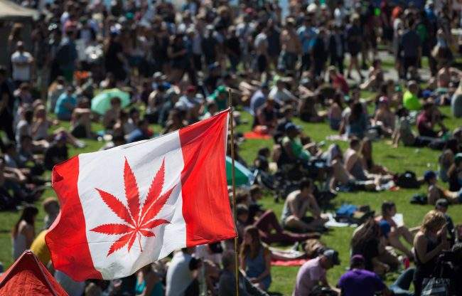 A marijuana flag flaps in the wind above the crowd at the annual 4/20 cannabis culture celebration at Sunset Beach in Vancouver, B.C., on Wednesday April 20, 2016. 