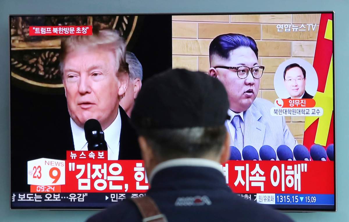 A man watches a TV screen showing North Korean leader Kim Jong Un, right, and U.S. President Donald Trump, left, at the Seoul Railway Station in Seoul, South Korea, Friday, March 9, 2018. Trump has accepted an offer of a summit from the North Korean leader and will meet with Kim Jong Un by May, a top South Korean official said Thursday, in a remarkable turnaround in relations between two historic adversaries. The signs read: " Kim Jong Un." (AP Photo/Ahn Young-joon).