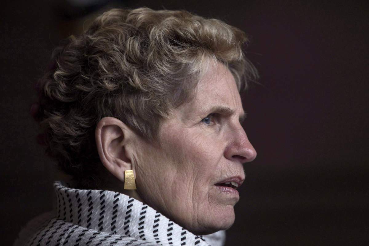 Ontario Premier Kathleen Wynne waits for Gov.Gen. Julie Payette outside the Ontario Legislature in Toronto on Tuesday, February 20, 2018. 