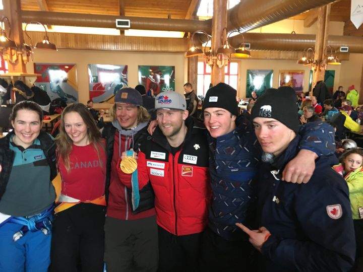 Olympic medallist Brady Leman flanked by young skiers at Nakiska Ski Area on March 9, 2018.