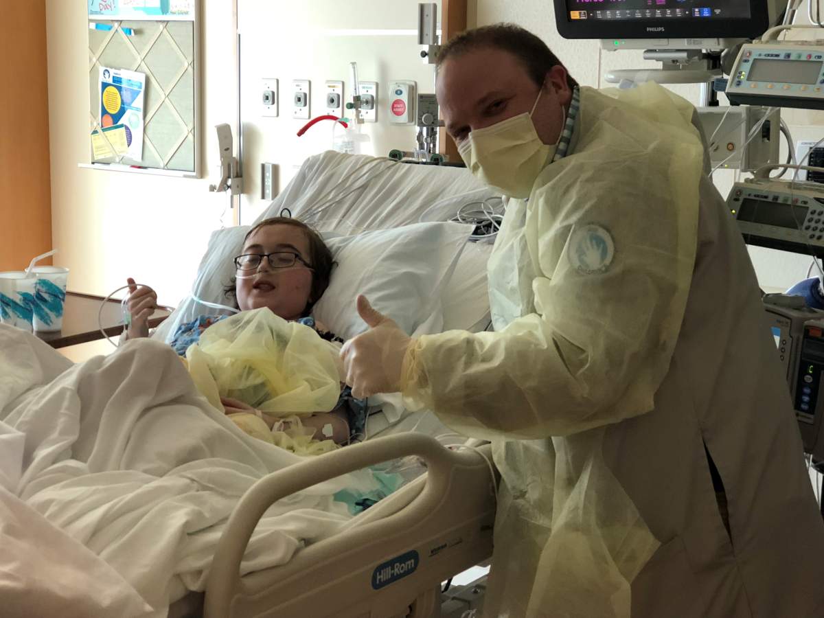 Austin and Dr. Thrush give a thumbs up a few days after the teen’s heart transplant.