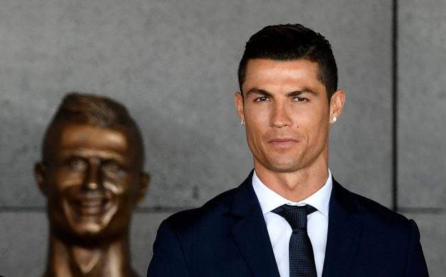 Portuguese footballer Cristiano Ronaldo stands past a bust at the Cristiano Ronaldo International Airport Madeira island, on March 29, 2017.


