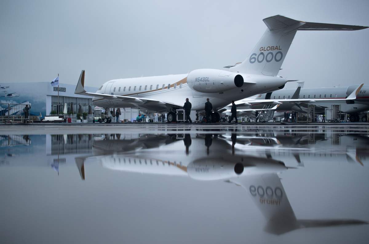 Men pass a Bombardier Global 6000 business jet before the start of the 2017 Asian Business Aviation Conference and Exhibition (ABACE) at Shanghai's Hongqiao Airport on April 10, 2017. 