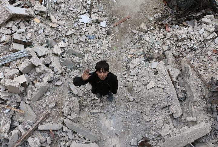 A Syrian boy raises his hand as he poses for a photo for the awareness campaign #Iamstillalive.