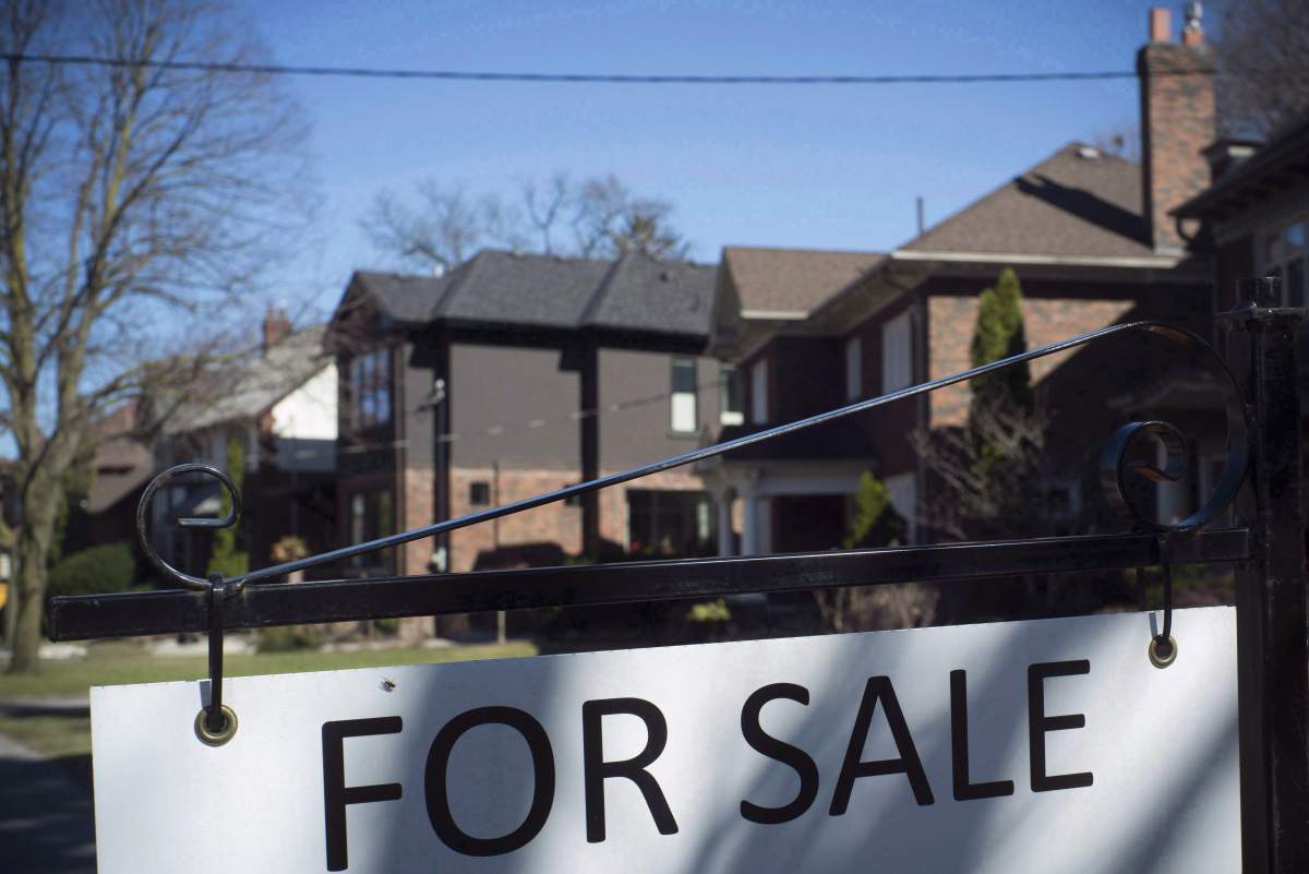 A "For Sale" sign is shown in front of west-end Toronto homes Sunday, April 9, 2017. The Toronto Real Estate Board says area home sales were up 12 per cent from September to October, pointing to a stronger fall market. THE CANADIAN PRESS/Graeme Roy.