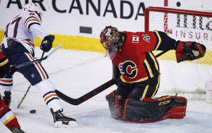 Edmonton Oilers centre Connor McDavid (97) pressures Calgary Flames goaltender Mike Smith (41) during first period NHL hockey action in Calgary, Tuesday, March 13, 2018.