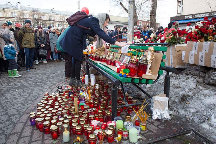 People lay flowers and candles for the victims of a fire in a multi-story shopping mall in the Siberian city of Kemerovo, Monday, March 26, 2018.