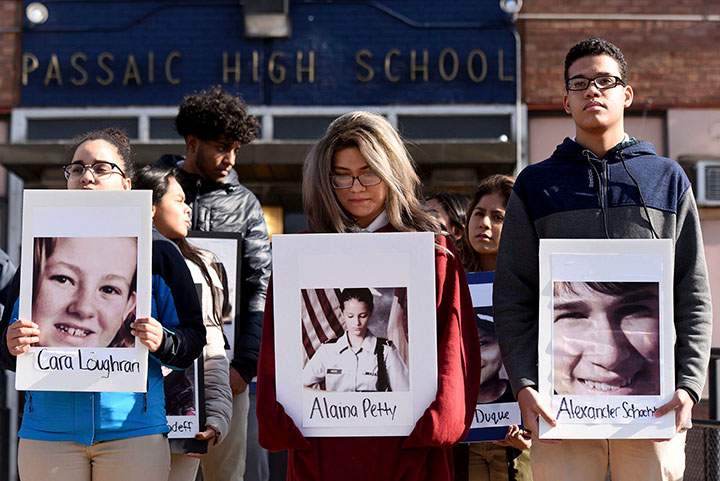 Students from Passaic High School hold photos of some of the 17 victims killed at Marjory Stoneman Douglas High School as they participate in a walkout to protest gun violence, Wednesday, March 14, 2018, in Passaic, N.J., one month after the deadly shooting inside a high school in Parkland, Fla.