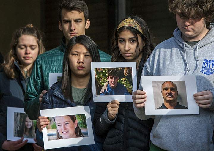 Students from City High Middle School in Grand Rapids, Mich., hold pictures of victims killed in the Marjory Stoneman Douglas High School shooting in Parkland, Fla., as they take part in a national school walkout to protest gun violence, Wednesday, March 14, 2018.