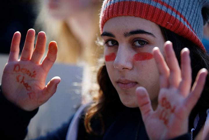 A sits with hundreds of others for 17 minutes of silence to honour the victims of the recent shooting at Florida’s Marjory Stoneman Douglas High School, as they take part in the national school, outside the White House in Washington, March 14, 2018.