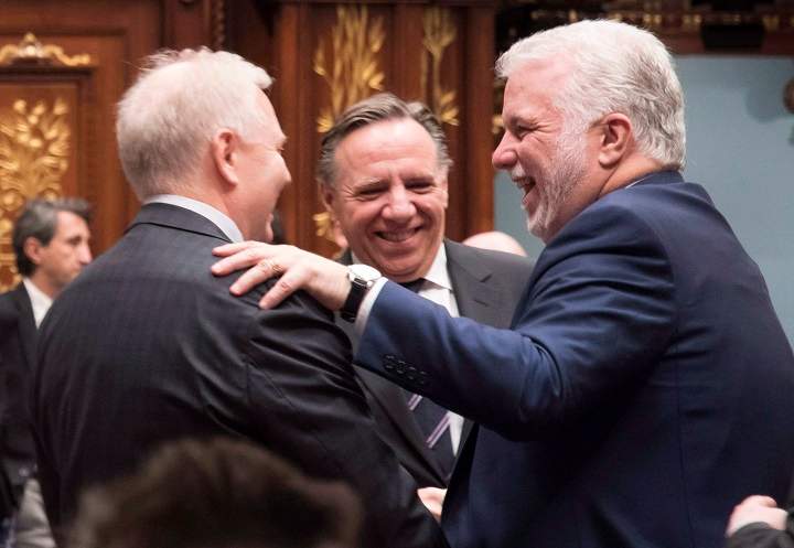 In this Dec. 2017 file photo, Quebec Premier Philippe Couillard, right, Parti Quebecois Leader Jean-Francois Lisee, left, and Coalition Avenir Quebec Leader Francois Legault, centre, exchange seasons greetings at the end of the fall session at the legislature in Quebec City. The six-month countdown to the provincial elections begins. Sunday, April 1, 2018.