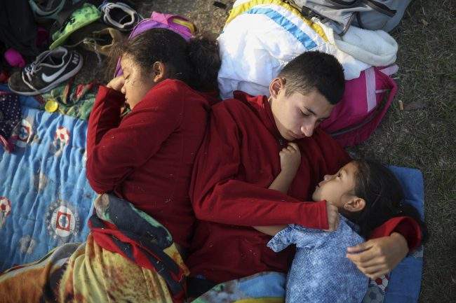 A trio of El Salvadorean siblings huddle together on a soccer field that served as a camp for migrants traveling with the “Stations of the Cross” caravan in Matias Romero, Mexico, April 4, 2018.