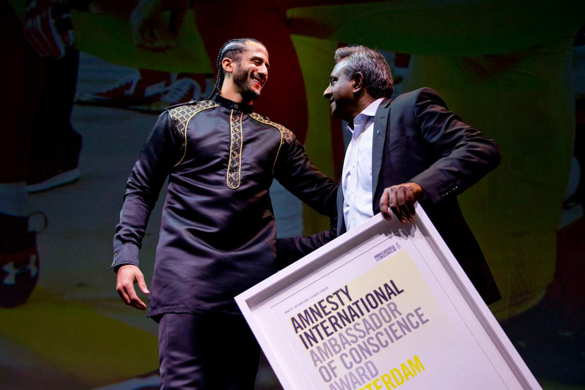 Former NFL quarterback and social justice activist Colin Kaepernick, left, receives the Amnesty International Ambassador of Conscience Award for 2018 from Amnesty International Secretary General Salil Shetty in Amsterdam, Saturday April 21, 2018.