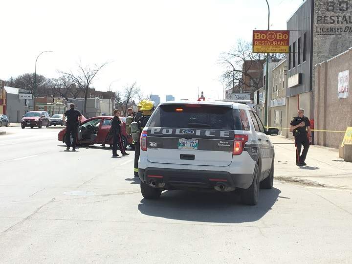 A vehicle blocks two lanes on Main Street in Winnipeg after a crash involving a police cruiser.