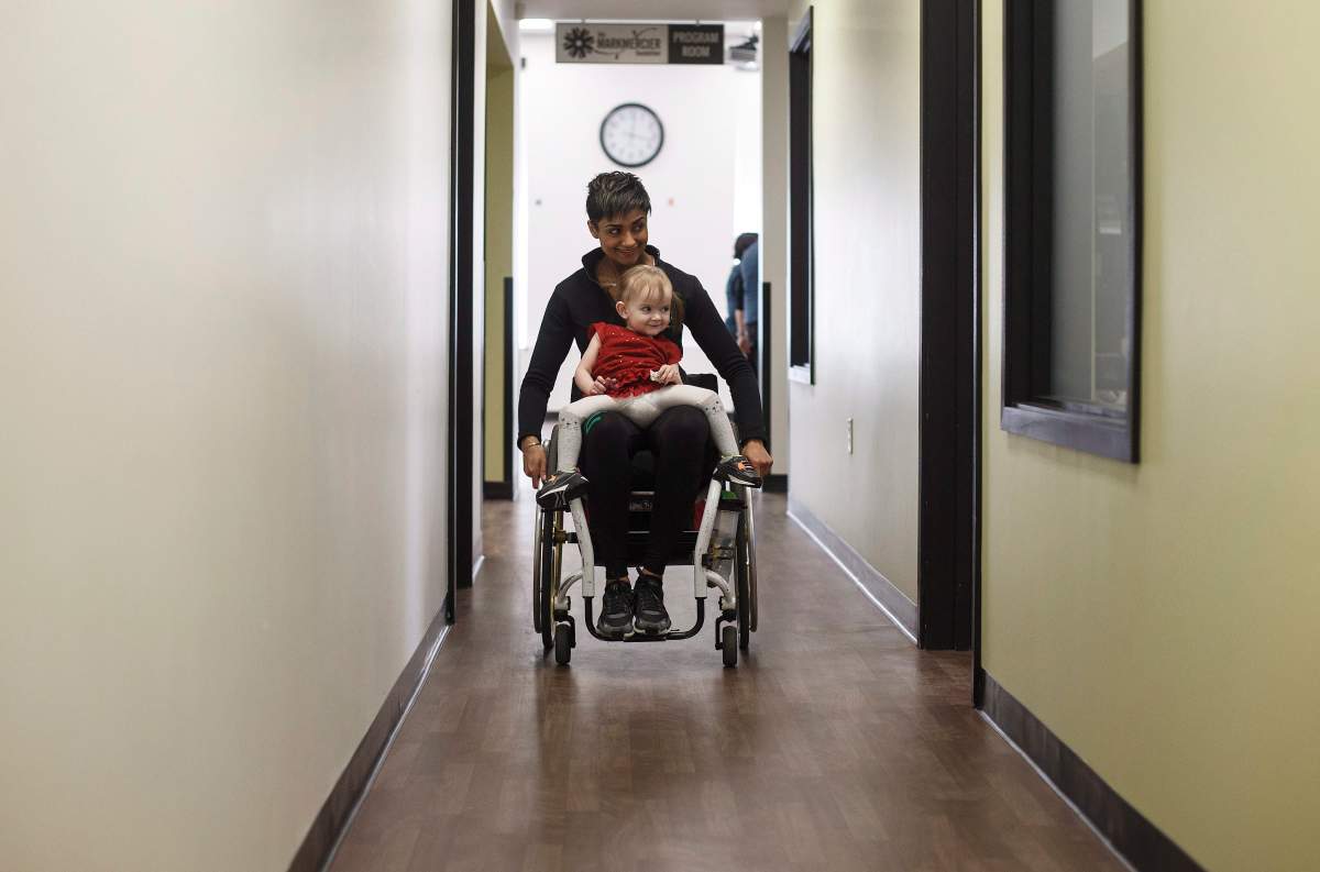 Evelyn Moore goes for a ride with Bean Gill, co-founder of ReYu Paralysis Recovery Centre in Edmonton Alta, on Wednesday April 4, 2018.