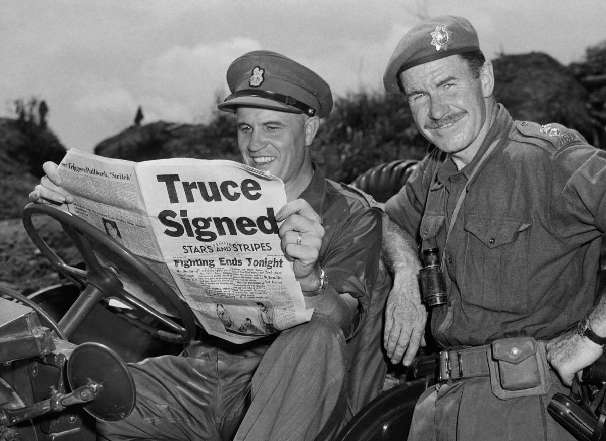 (Original Caption) Brigadier General Jean Allard, commanding officer of the Canadian Brigade, breaks word of the truce to Lieutenant Colonel K.L. Campbell of Toronto and Ottowa who commands the 3rd Battalion of the RCRS, which received heavy shelling on the last day with no casualties.
