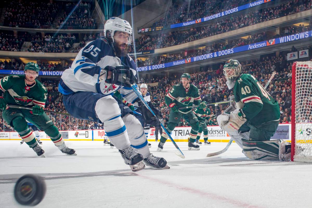 Devan Dubnyk of the Minnesota Wild defends against Mathieu Perreault of the Winnipeg Jets during the game at the Xcel Energy Center on January 13, 2018 in St. Paul, Minnesota.