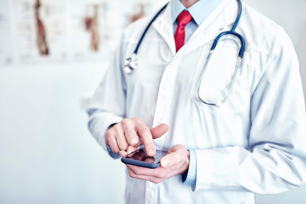 Doctor with smartphone at the office. 
