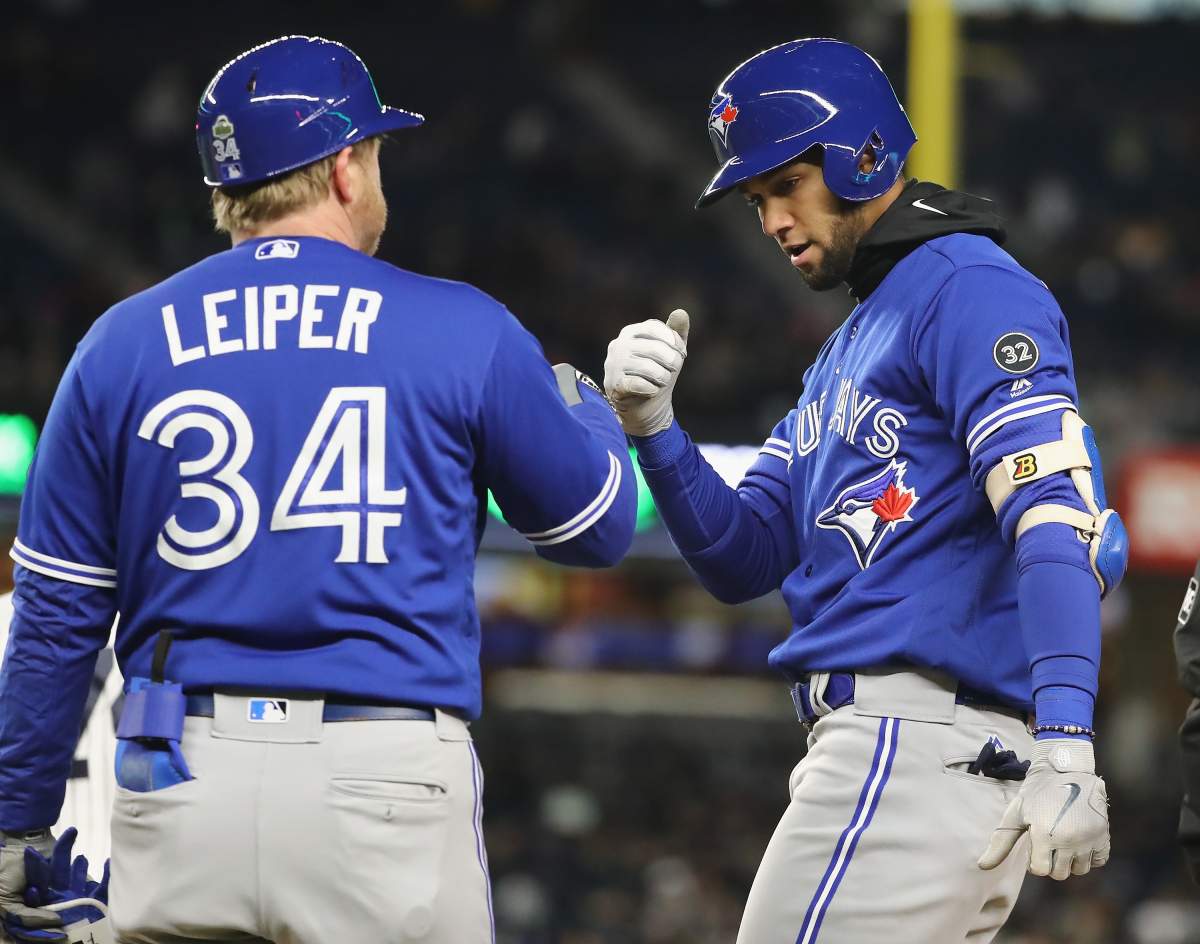 NEW YORK, NY - APRIL 20:  Lourdes Gurriel Jr.#13 of the Toronto Blue Jays is congratulated by first base coach Tim Leiper #34 after he hit an RBI single in the fifth inning against the New York Yankees at Yankee Stadium on April 20, 2018 in the Bronx borough of New York City. 
