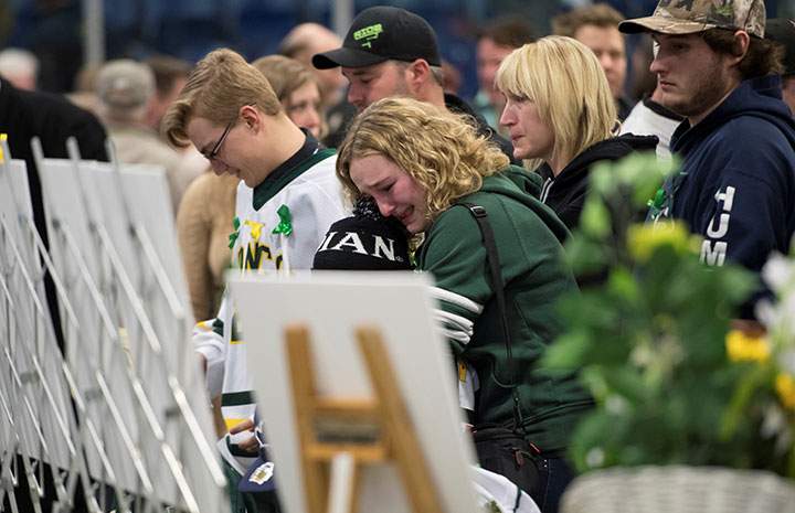 Mourners comfort each other during a vigil at the Elgar Petersen Arena, home of the Humboldt Broncos, to honour the victims of a fatal bus accident, April 8, 2018.