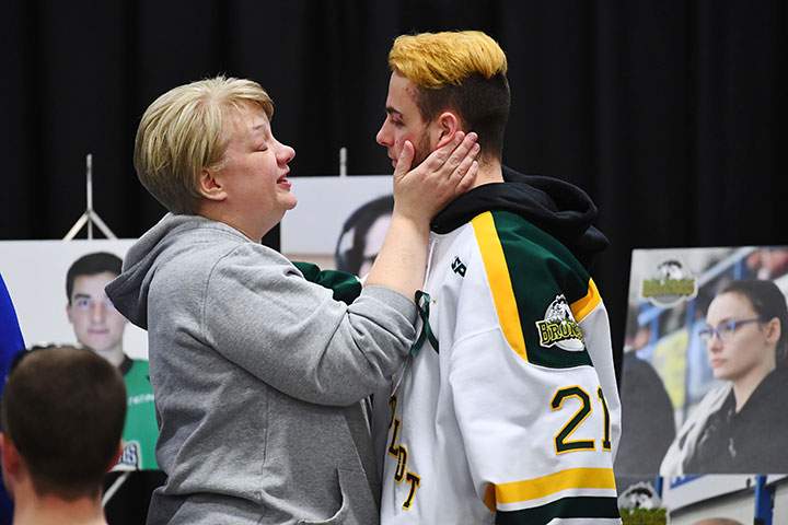 Humboldt Broncos’ Nick Shumlanski, who was released from hospital Sunday, is comforted by a mourner during a vigil at the Elgar Petersen Arena, to honour the victims of a fatal bus accident, April 8, 2018.