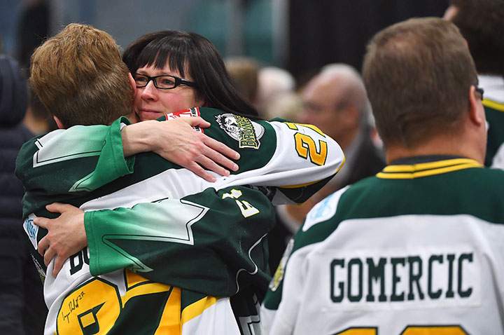 Mourners comfort each other as people attend a vigil at the Elgar Petersen Arena, home of the Humboldt Broncos, to honour the victims of a fatal bus accident, April 8, 2018.