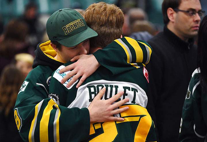 Mourners comfort each other during a vigil at the Elgar Petersen Arena, home of the Humboldt Broncos, to honour the victims of a fatal bus accident, April 8, 2018.