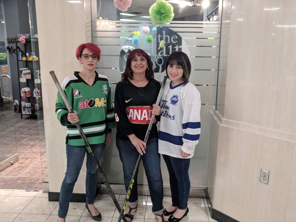 Julia Salvador (right) standing out front of the Hair Shoppe with her coworkers.