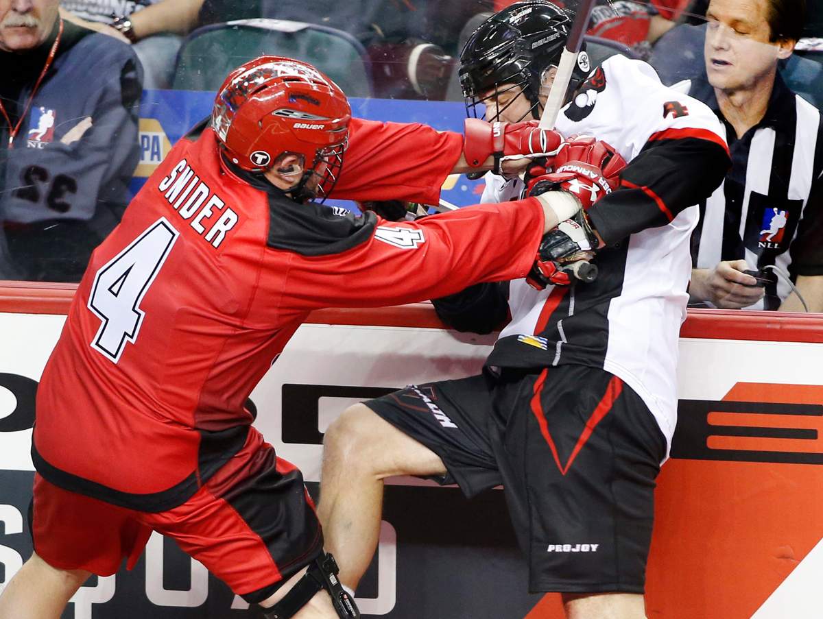Vancouver Stealth’s Chris O’Dougherty, right, loses the ball as he is hit by Calgary Roughnecks’ Geoff Snider during NLL lacrosse action in Calgary, Alberta on Saturday, Jan. 3, 2015. THE CANADIAN PRESS IMAGES/Larry MacDougal