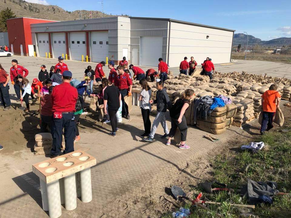 Grade 6 class and BC Forest Service personnel bagging two truck loads of sand at Oliver Fire Department. 