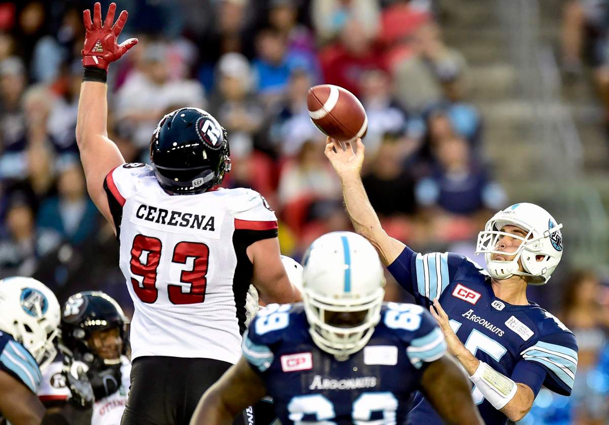 Toronto Argonauts quarterback Ricky Ray (15) lets a pass fly as Ottawa Redblacks defensive lineman Jake Ceresna (93) attempts to block during first half CFL action in Toronto, Monday, July 24, 2017.