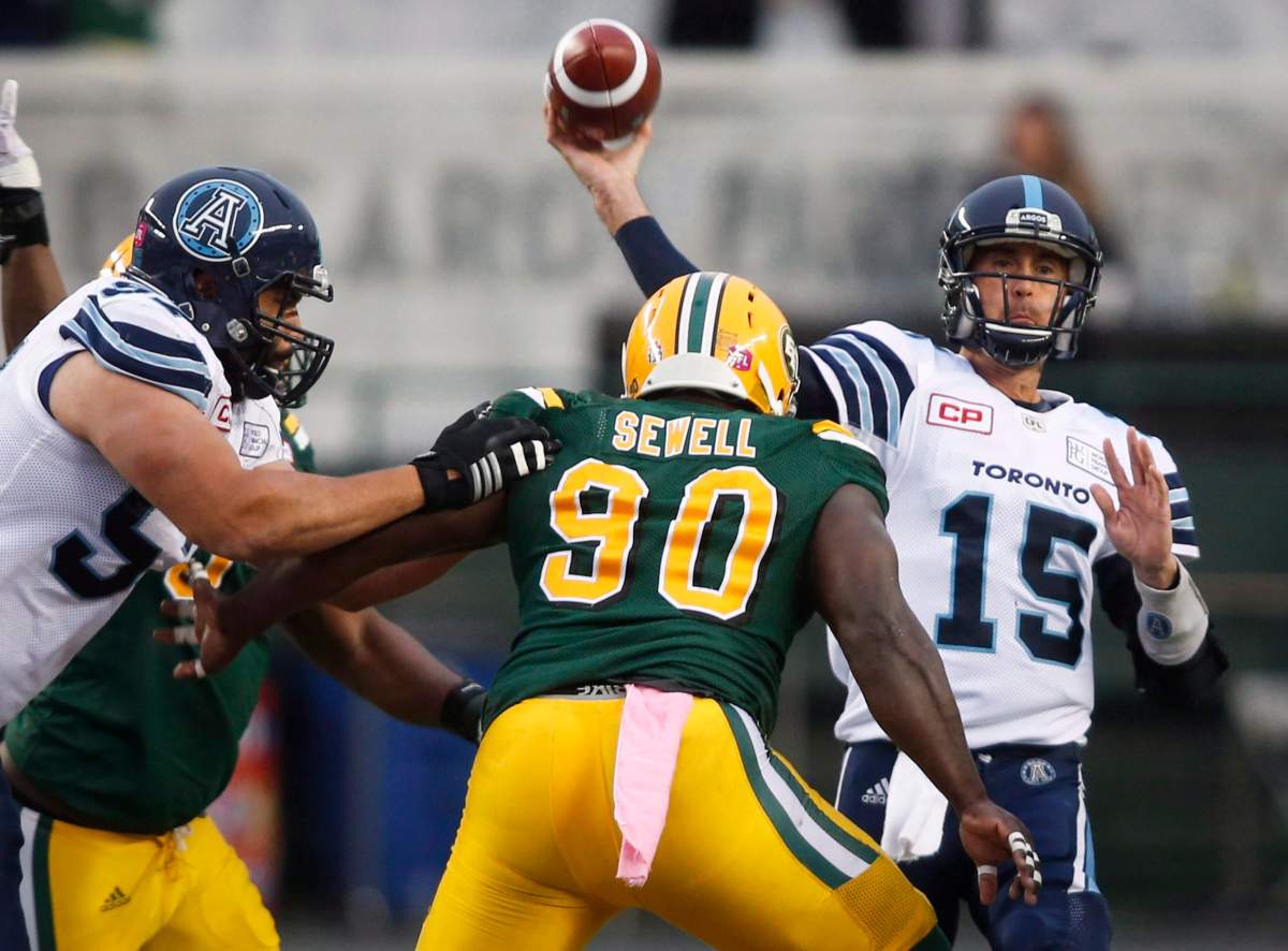 Toronto Argonauts quarterback Ricky Ray, right, throws the ball under pressure from Edmonton Eskimos' Almondo Sewell during first quarter CFL football action in Edmonton, Saturday, Oct. 14, 2017.