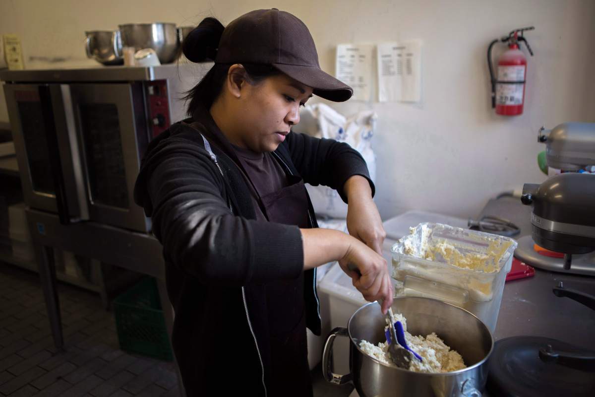 A baker at Dlish Cupcakes, a bakery that uses vanilla every day, prepares the day’s first batch in Toronto on March 17, 2018.