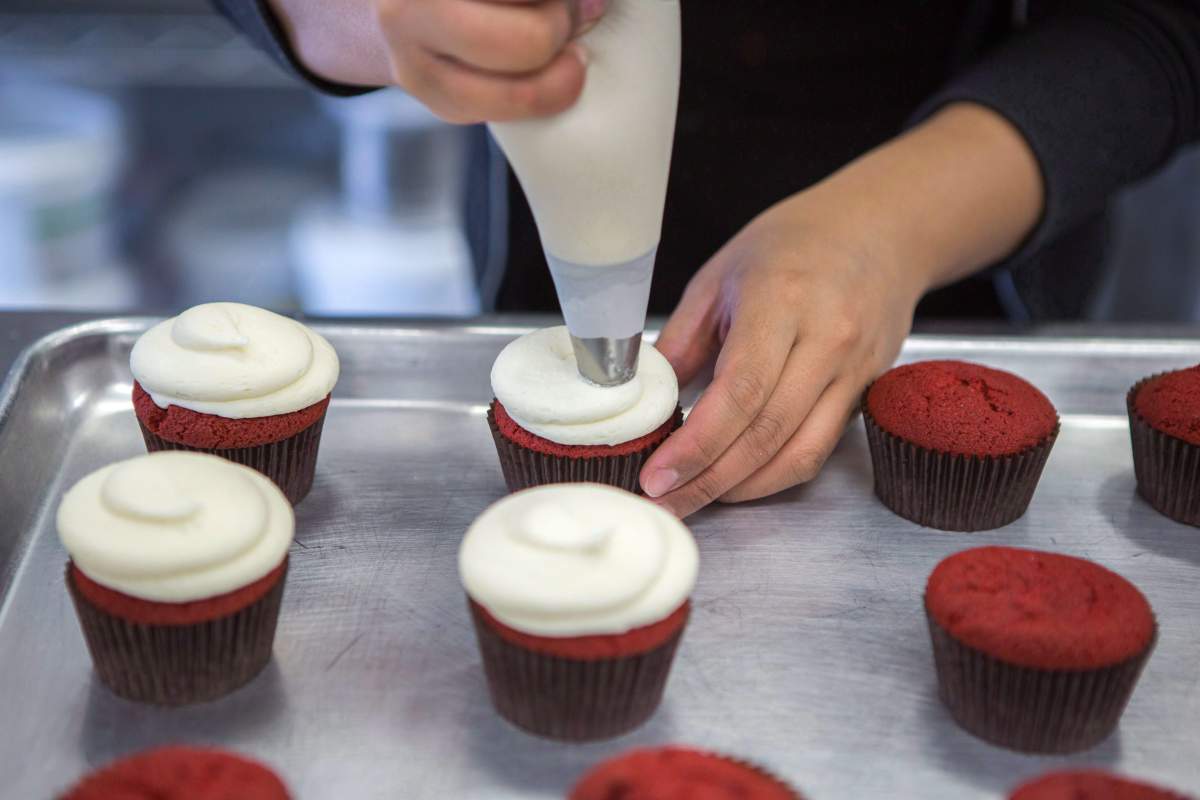 A baker at Dlish Cupcakes, a bakery that uses vanilla every day, prepares the day’s first batch in Toronto on Saturday, March 17, 2018.
