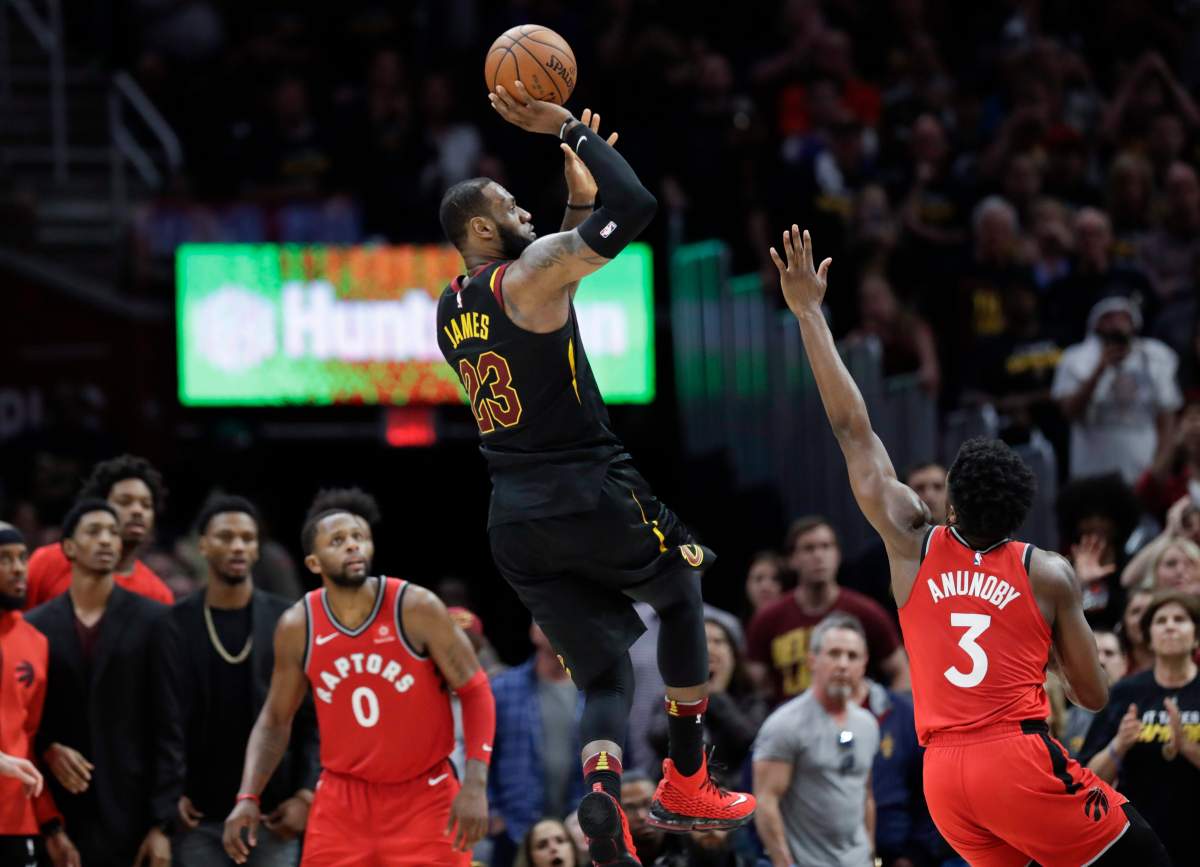 Cleveland Cavaliers' LeBron James (23) hits the game-winning shot as Toronto Raptors' OG Anunoby (3) and CJ Miles (0) watch during the second half of Game 3 of an NBA basketball second-round playoff series, Saturday, May 5, 2018, in Cleveland. The Cavaliers defeated the Raptors 105-103. (AP Photo/Tony Dejak).