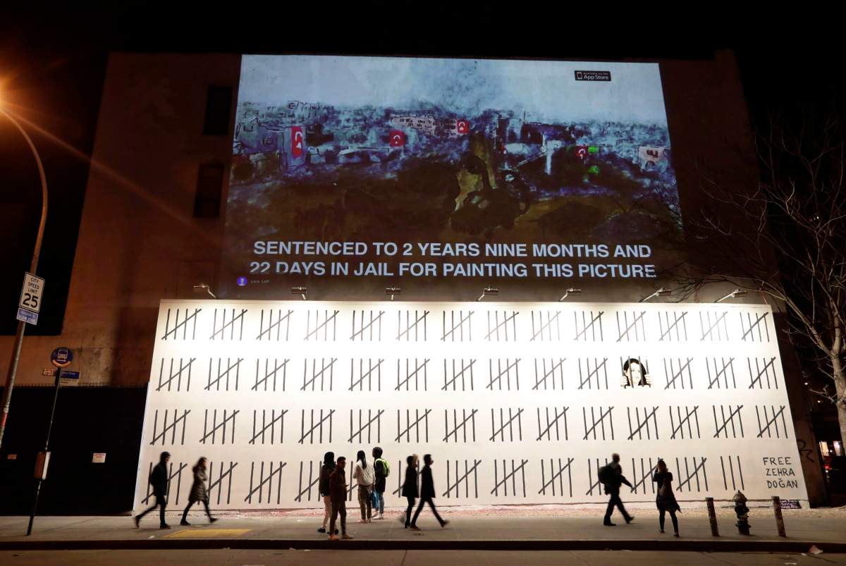 People pass by a mural by British graffiti artist Banksy protesting the imprisonment of Turkish artist Zehra Dogan in New York on March 16, 2018. An unauthorized exhibition featuring the work of mysterious British graffiti artist Banksy is headed to Toronto. Organizers say "The Art of Banksy" will make its North American premiere in the city on June 13 at 213 Sterling Road. Banksy's former agent, Steve Lazarides, curated the exhibit. 
