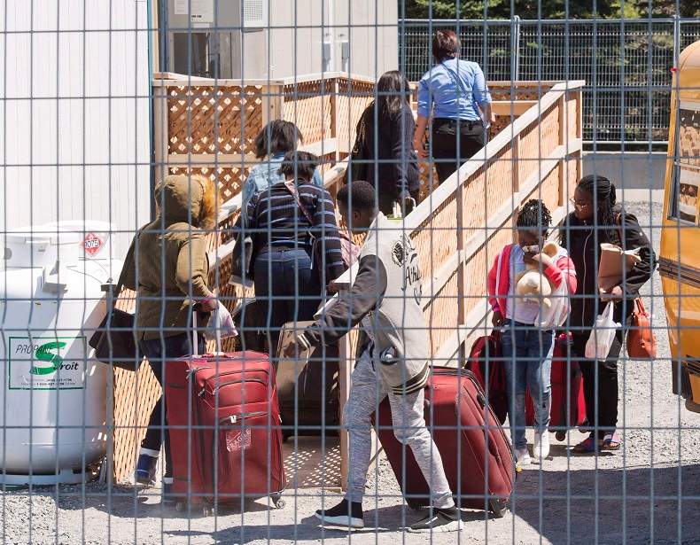 A group of asylum seekers arrive at the temporary housing facilities at the border crossing, Wednesday May 9, 2018 in St. Bernard-de-Lacolle, Que. Almost 96 per cent of asylum seekers who have crossed illegally into Canada so far in 2018 have done so through the Quebec border.