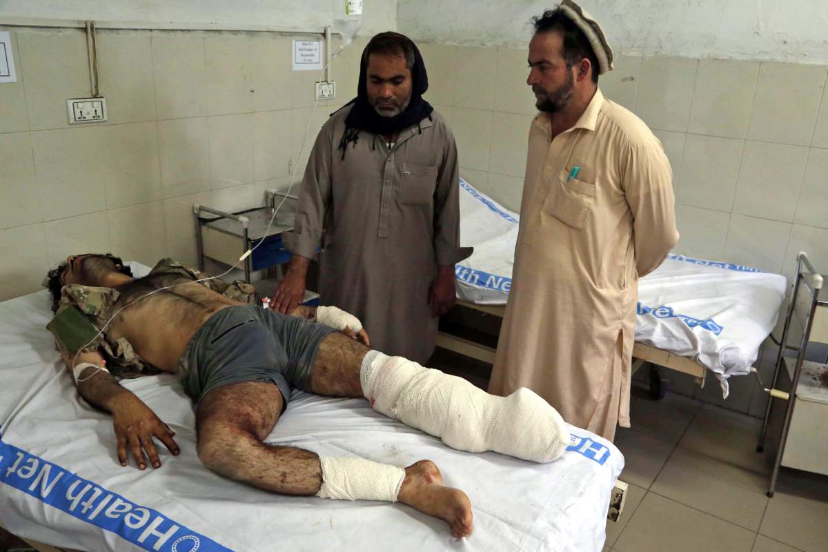 A man who was injured in bomb blasts at a cricket stadium is visited by relatives after having received medical treatment at a hospital in Jalalabad, Afghanistan, 19 May 2018. A

.