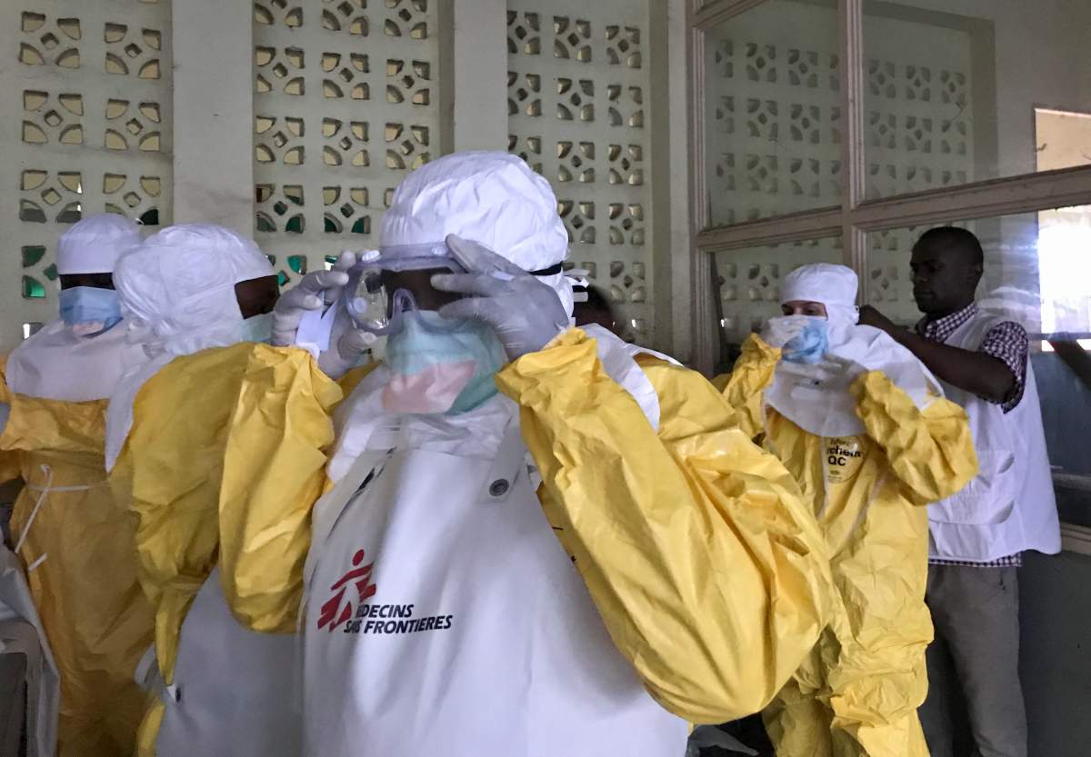In this photo taken Sunday, May 20, 2018, a team from Medecins Sans Frontieres (Doctors Without Borders) dons protective clothing and equipment as they prepare to treat Ebola patients in an isolation ward of Mbandaka hospital in Congo.