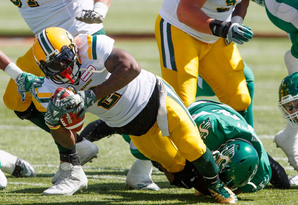 Saskatchewan Roughriders tackle Edmonton Eskimos C.J. Gable (2) during first half CFL pre-season action in Edmonton, Alta., on Sunday May 27, 2018. 