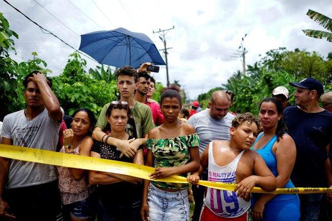 People look on near of the wreckage of a Boeing 737 plane that crashed in the agricultural area in Boyeros, around 20 km (12 miles) south of Havana, on Friday shortly after taking off from Havana’s main airport in Cuba, May 18, 2018.