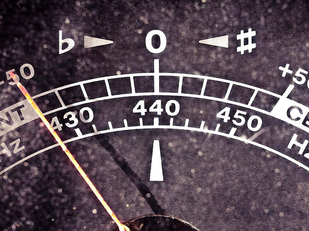A vintage plastic guitar tuner measures 440 Hz.
