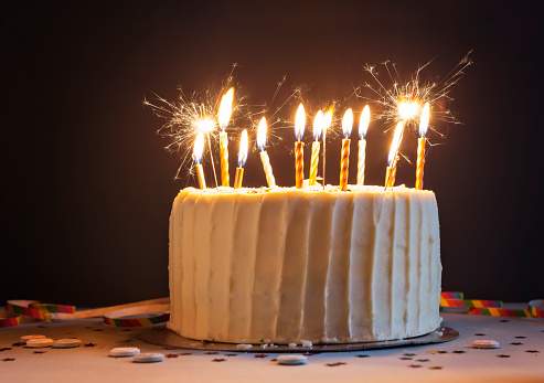 A stock photo of a birthday cake with candles and sparklers.